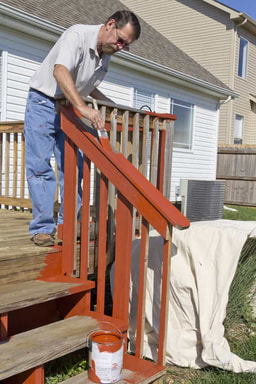 painter staining a deck in Oshawa